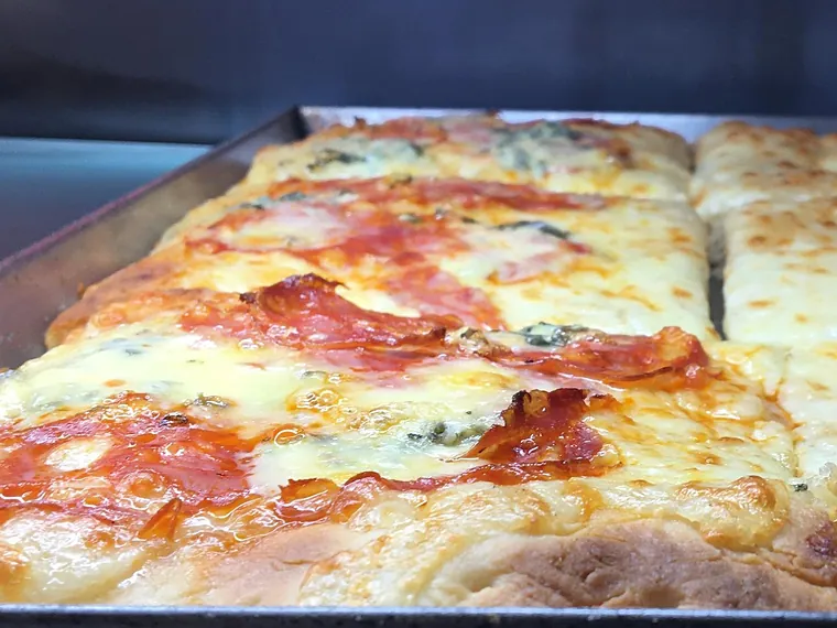 Pizza in teglia con salame, mozzarella e gorgonzola appena sfornata, dalla pagina Facebook del locale